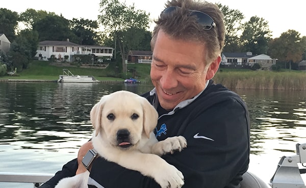 Dr. Hanson hugging a puppy while on a lake